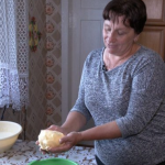 На Волині жінка збиває масло у дерев’яній маслобійці, як колись бабуся