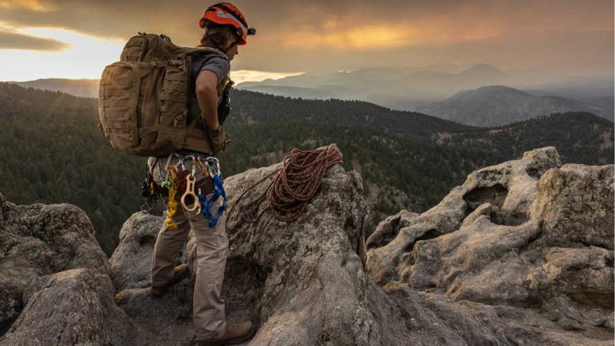 Чоловік у тактичних штанах кольору койот на відпочинку у горах
